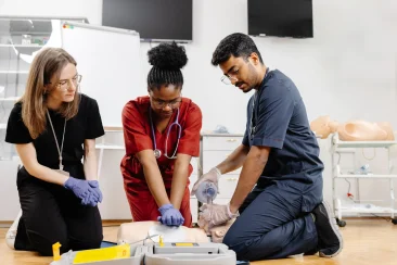 Two medical aide students in a BLS class demonstrates their BLS skills with hospital dummy