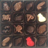Assorted chocolates shaped like anatomical organs and body parts arranged in a grid inside a box.
