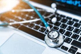A stethoscope resting on a laptop keyboard, symbolizing the intersection of healthcare and technology.