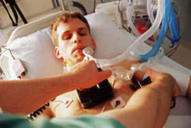 man in hospital bed and aed