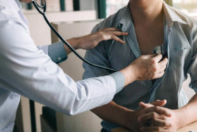 Doctor using a stethoscope to listen to a patient's chest during a medical examination.