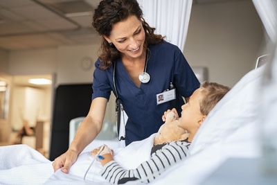 a nurse is with a male child lying on a hospital bed