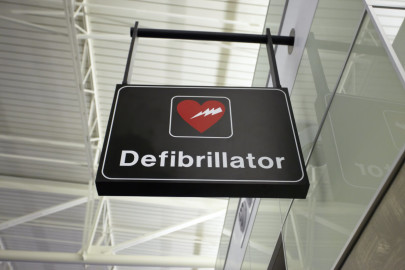 A hospital room signage displays the logo of defibrillator where the double sequential AED equipment is located.
