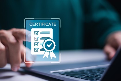 A man views an online certificate with a verified checkmark on a laptop