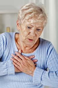 woman holding chest in pain