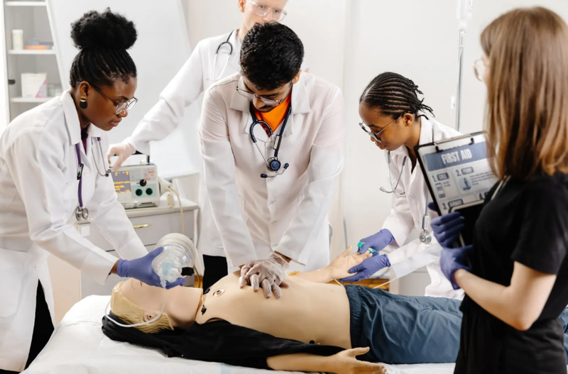 group-of-medical-students-practicing-compressions-on-adult-dummy