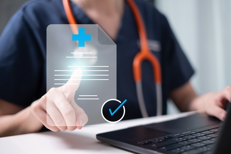 A female healthcare professional working_on_a_laptop_and_displays a certificate with a check mark featured photo